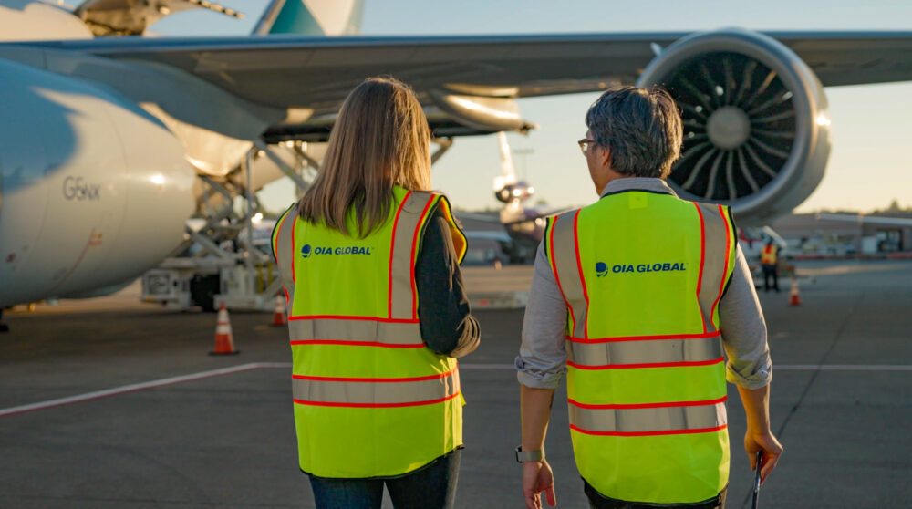 OIA Global's new brand messaging, as represented by two air freight operations employees.