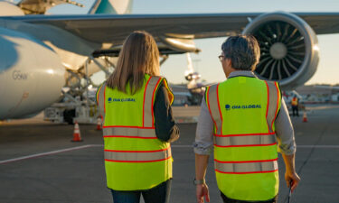 OIA Global's new brand messaging, as represented by two air freight operations employees.